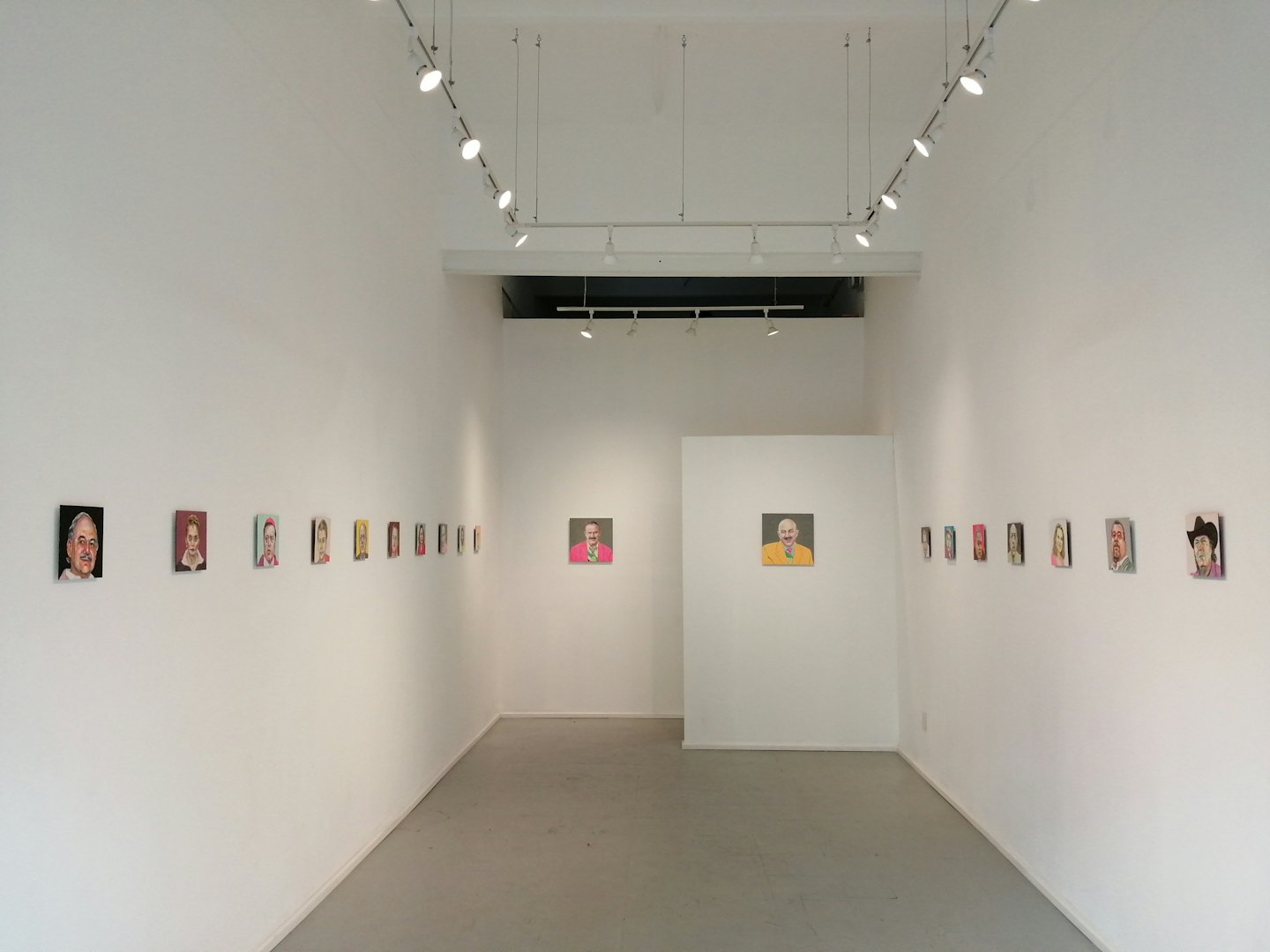 Konstgallerinsida som visar rader av små fyrkantiga målningar.